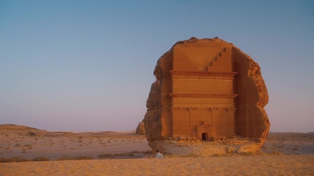 Traveling to Saudi Arabia and discovering tombs in Hegra, AlUla. Two people walk to visit a historical Arabic cultural heritage in the desert