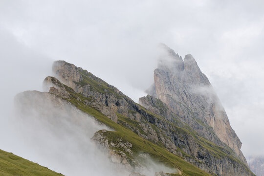 iconic mountain massif in fog at seceda italian alps (hiking walking trail ski lift cable car tourism) popular travel destination weather rain cloudy foggy cloud low visibility engulfed mist misty