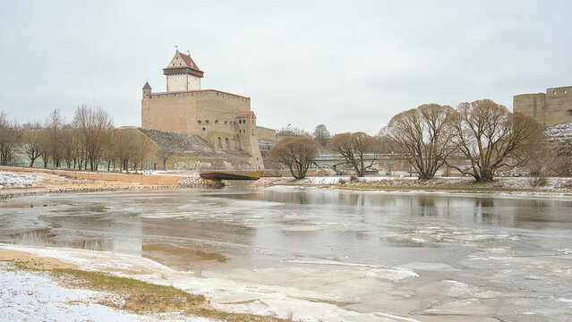 Hermann castle along frozen narva river on a cold winter day on the border between Russia and Estonia 