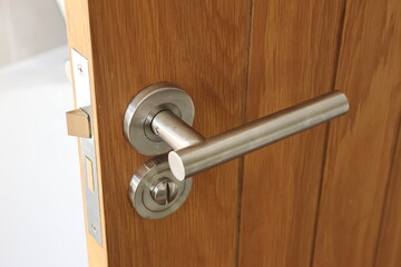 Obraz premium A door handle is shown in a wooden door