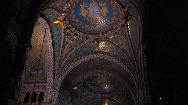 Vaulted church ceiling with mosaics and chandeliers in Lyon France