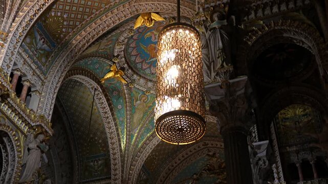 Ornate vaulted church ceiling with arches and chandelier in Lyon
