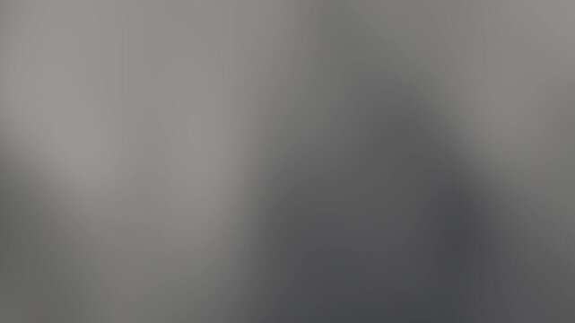 Abstract blurred grey gradient background viewed from directly above with soft shadows and subtle texture