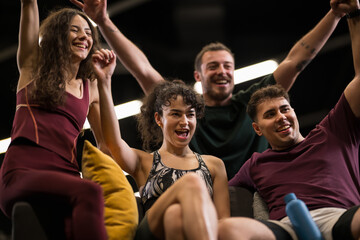 Obraz premium Group of friends celebrating after a fitness class in a gym with bright lights and a lively atmosphere during the evening session