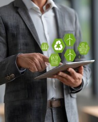 A person in a suit interacts with a tablet displaying green icons representing sustainability and technology in a modern office environment from a close-up viewpoint