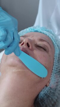 Cosmetology treatment - applying moisturizing gel on the skin of adult woman