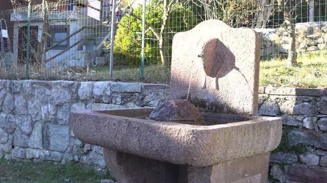 stone fountain in Rango, trentino Italy, winter time