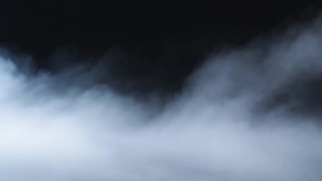 Soft fog rolling slowly across a dark background