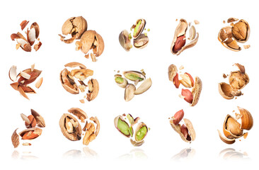 Set of various crushed nuts in the air isolated on a white background