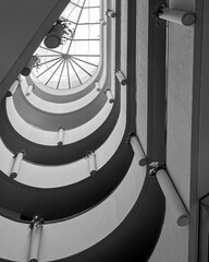 Abstract spiral architecture in black and white with skylight, modern geometric atrium interior