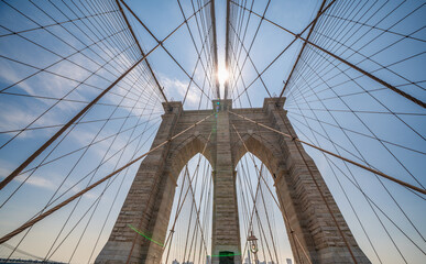 Fototapeta premium Brooklyn Bridge walkway perspective with cables and urban cityscape of NYC