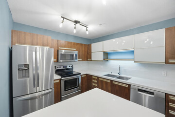 Kitchen with a white counter and a stainless steel sink