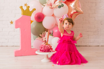 Fototapeta premium Baby girl at first birthday with smash cake