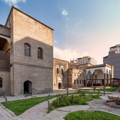 Fototapeta premium Historic Gupgupoulu Konagi, Kayseri Ethnography Museum courtyard in Kayseri, Turkey. Traditional stone architecture, lush garden with roses under a sunny sky