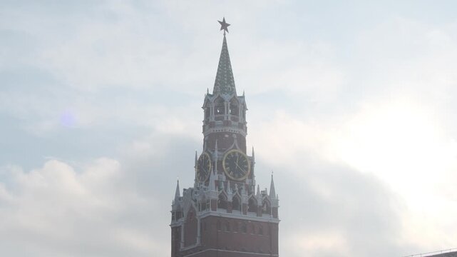 Spasskaya Tower of the Moscow Kremlin in winter with light snowfall. Russian winter: Spasskaya Tower of the Kremlin against a cloudy sky with snow. 
