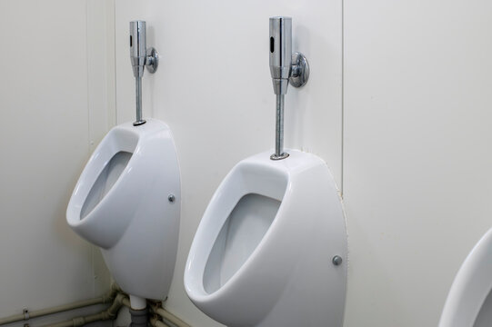 Modern Public Restroom With Dual Urinals And Chrome Flush Valves In A Clean Setting