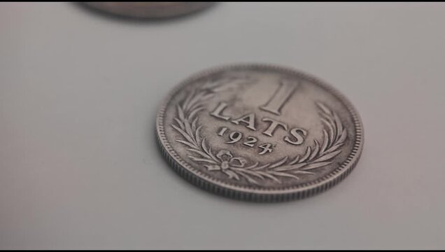 A macro shot of historic Latvian Lats 1 Lats coins spinning with obverse and reverse