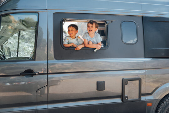 Happy children enjoying a road trip in camper van
