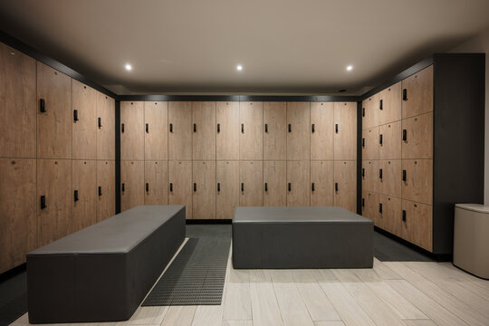 Modern gym locker room with wooden lockers and benches