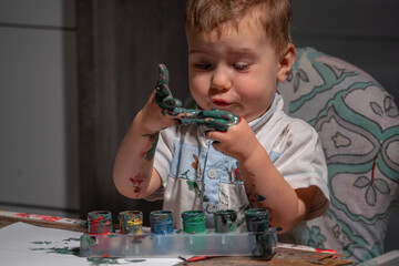 Candid photo of a toddler painting at home, showing real emotions and natural curiosity during a...