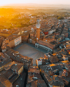 Aerial view of Siena historic center with the iconic Piazza del Campo illuminated by warm sunset light