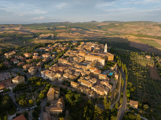Obraz premium Aerial view of the historic town of Pienza at sunset, with warm golden light illuminating medieval buildings and rolling hills of Val d’Orcia. A UNESCO World Heritage site in Tuscany, Italy