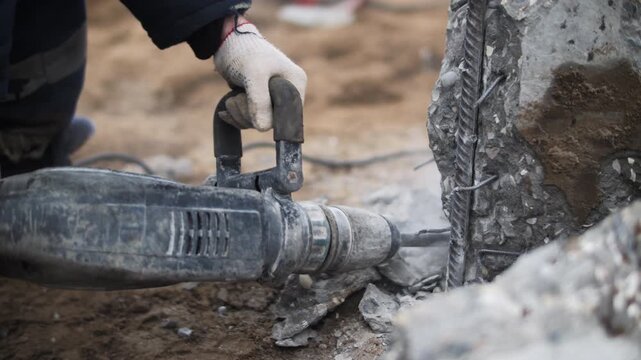 Pneumatic breaker chipping reinforced pile edge on foundation site