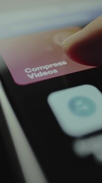 Finger taps the button labeled Compress Videos