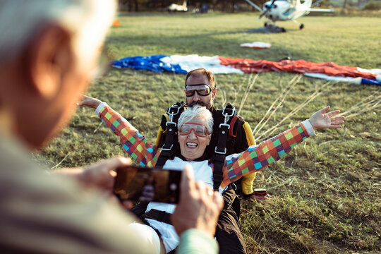 Senior woman landing from tandem skydive at airfield