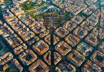 Clean aerial sunrise view of Barcelona highlighting the Eixample grid pattern and dense residential architecture. A striking example of modern urban design in southern Europe © Vgallery