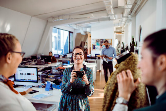 Young photographer shooting clothing in creative office studio