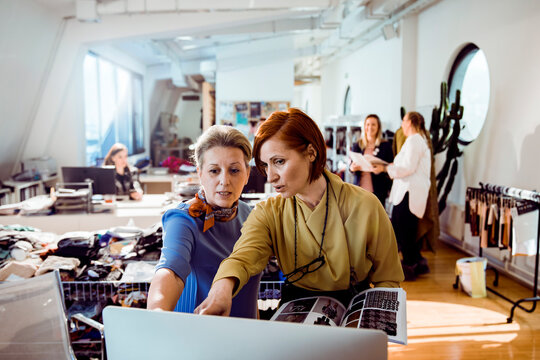 Female fashion designers collaborating in modern studio office