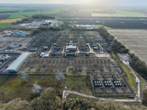 Aerial view of the National Grid Walpole Substation, a symphony of metal and power amidst the sprawling fields, Wisbech, United Kingdom.