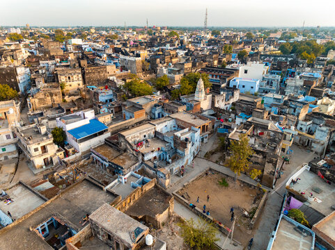 Aerial view of the old city bathed in warm sunlight, revealing the intricate patterns of rooftops and streets, a tapestry of urban life, Sambhar, Rajasthan, India.