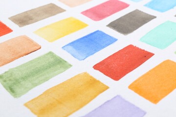 Fototapeta premium Painted watercolor strokes on white sheet of paper, closeup