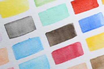 Fototapeta premium Painted watercolor strokes on white sheet of paper, top view