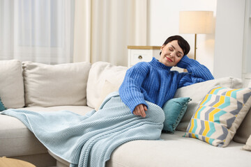 Fototapeta premium Beautiful woman resting on sofa at home. Space for text
