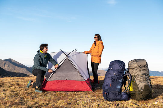Smiling friends enjoying teamwork while finishing mountain camp