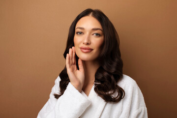 Beauty care. Portrait of young woman with flawless skin touching face and looking at camera,...