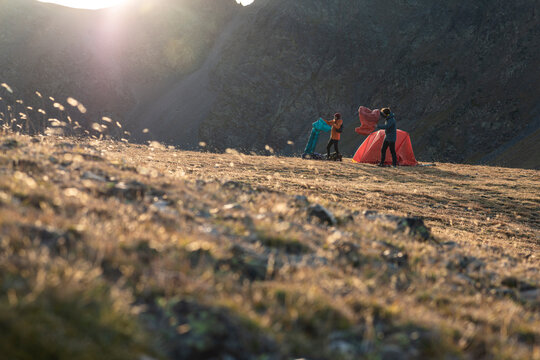 Evening camp routine unfolding beneath dramatic alpine backdrop