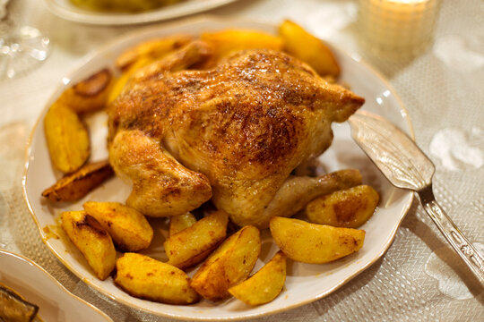 Whole baked chicken with potato slices