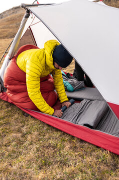 Hiker packing sleeping pad during campsite breakdown routine