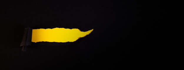 Torn paper on black background with yellow space for your message.