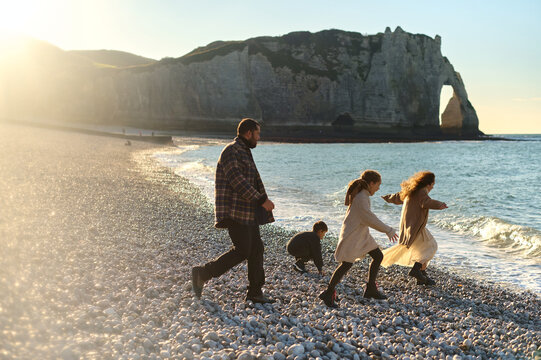 family have a fun on a rocky beach of Etretat