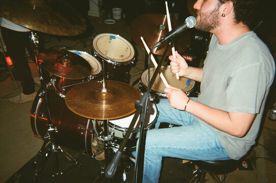 Young Man Plays the Drums at a Concert
