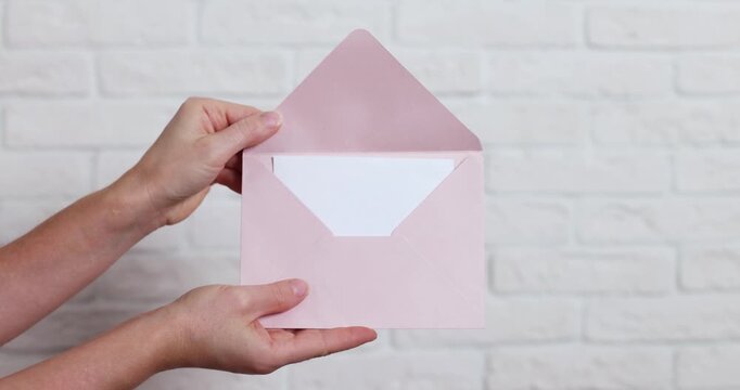 a paper envelope in a woman's hands on a light background
