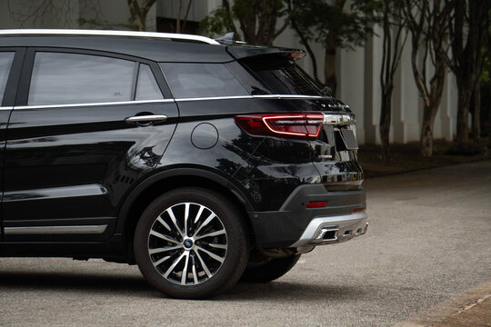Rear quarter view of a black Ford Territory Titanium, High end SUV external shot on tree lined road
