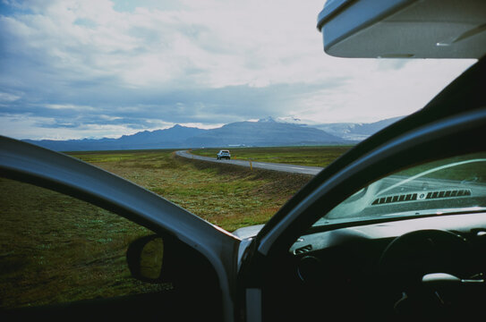Distant view of car on the empty road, view from the car parked aside 