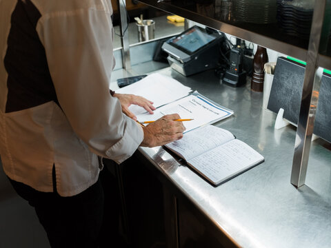Chef Preparing Meal Plans in a Busy Kitchen Environment