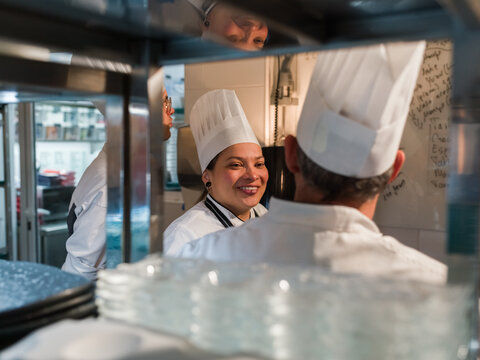 Smiling chefs talking in kitchen 